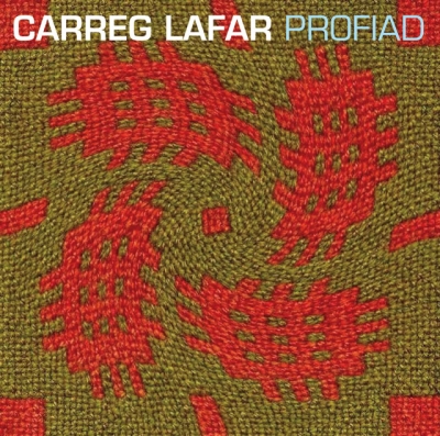 A square olive and brown woven-texture cover with scattered red abstract motifs and the title “CARREG LAFAR PROFIAD” across the top.